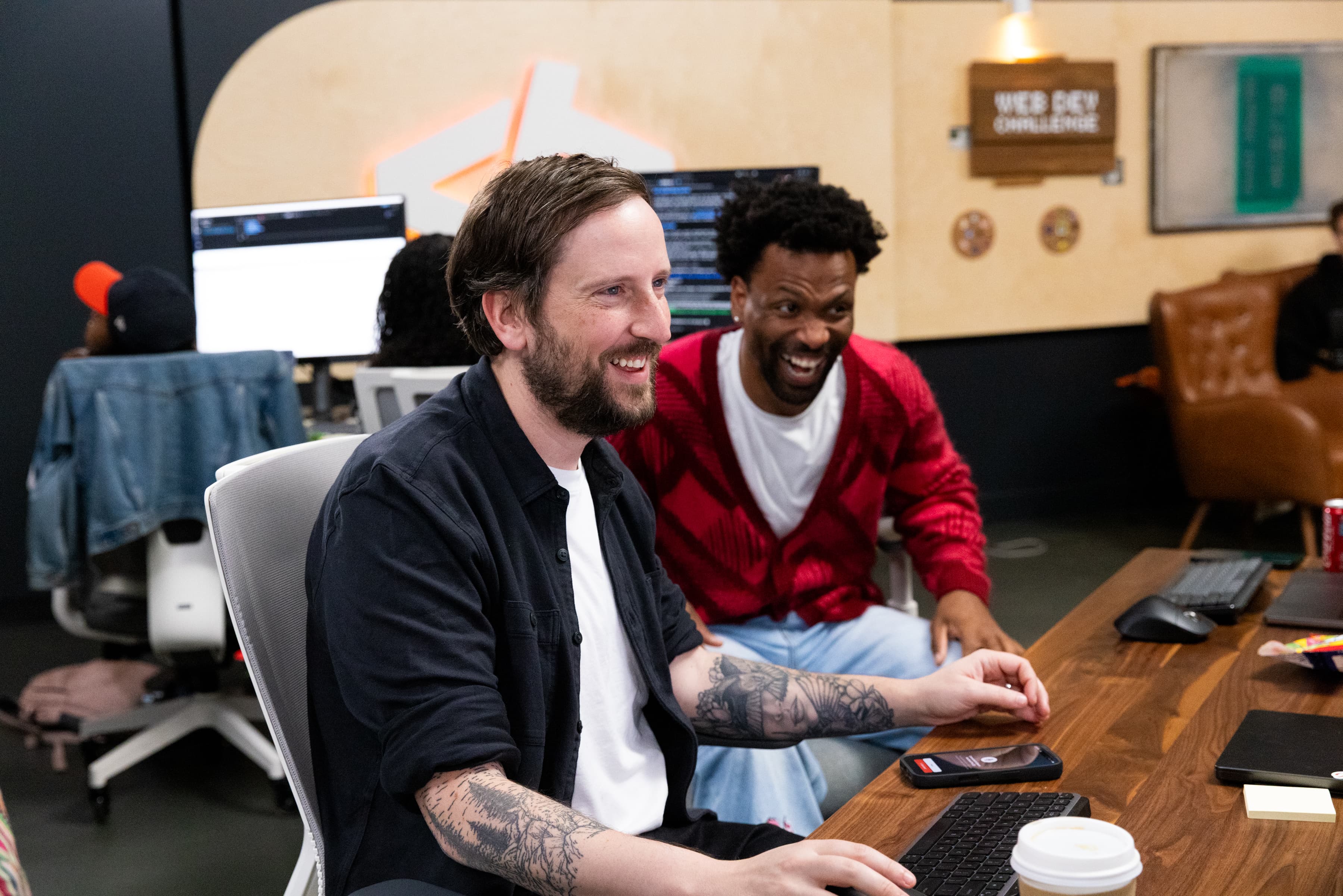 Two builders laughing at the desk during the challenge