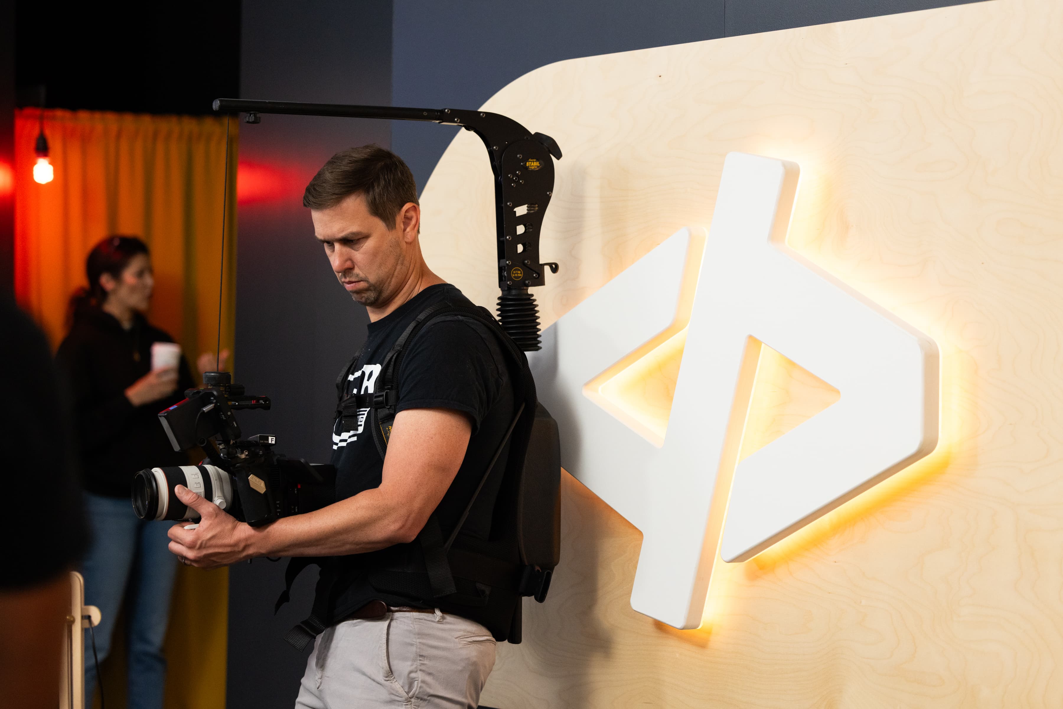 A camera operator filming in front of the Inngest mark